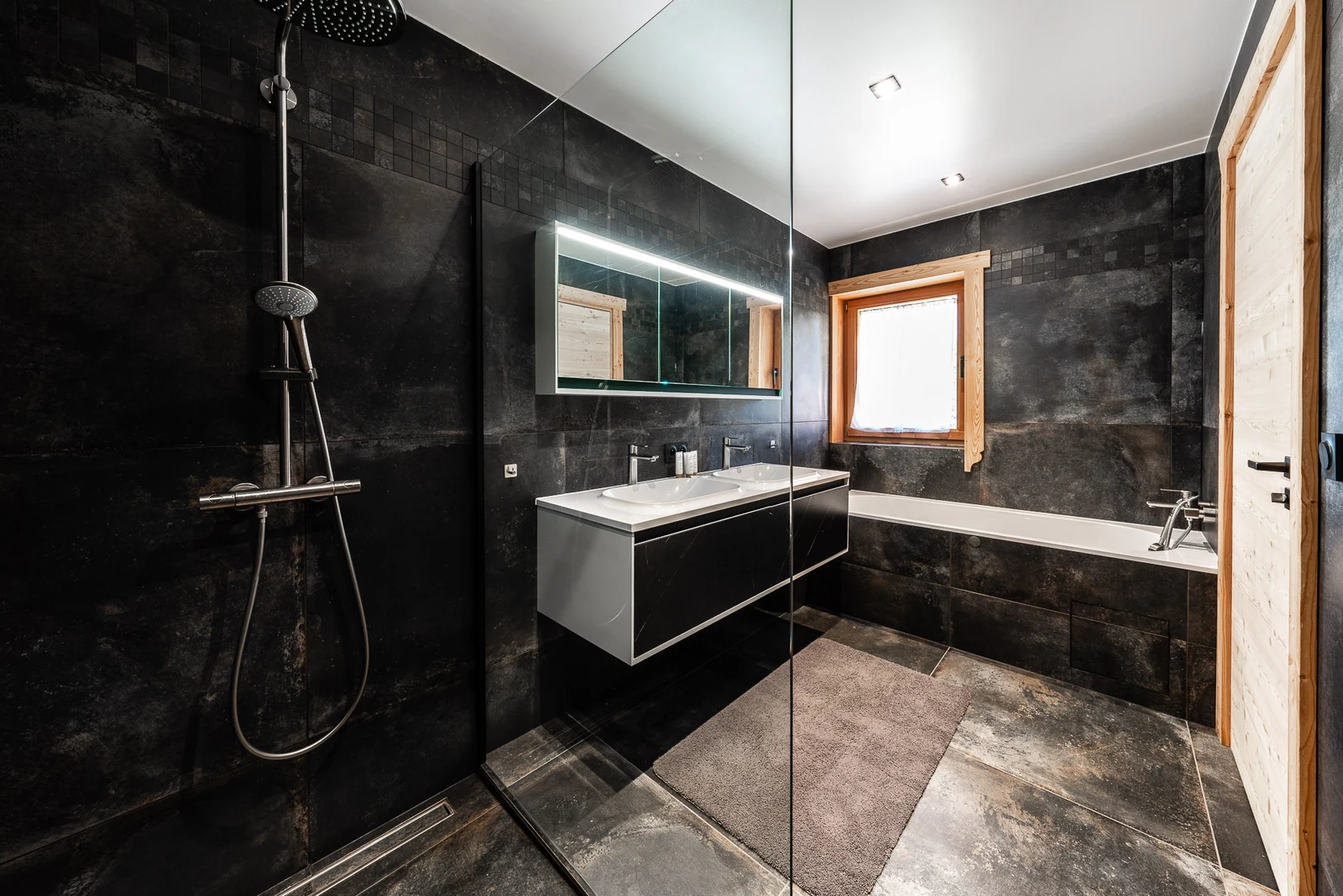 Chalet L'Étoile — salle de bains noire avec baignoire