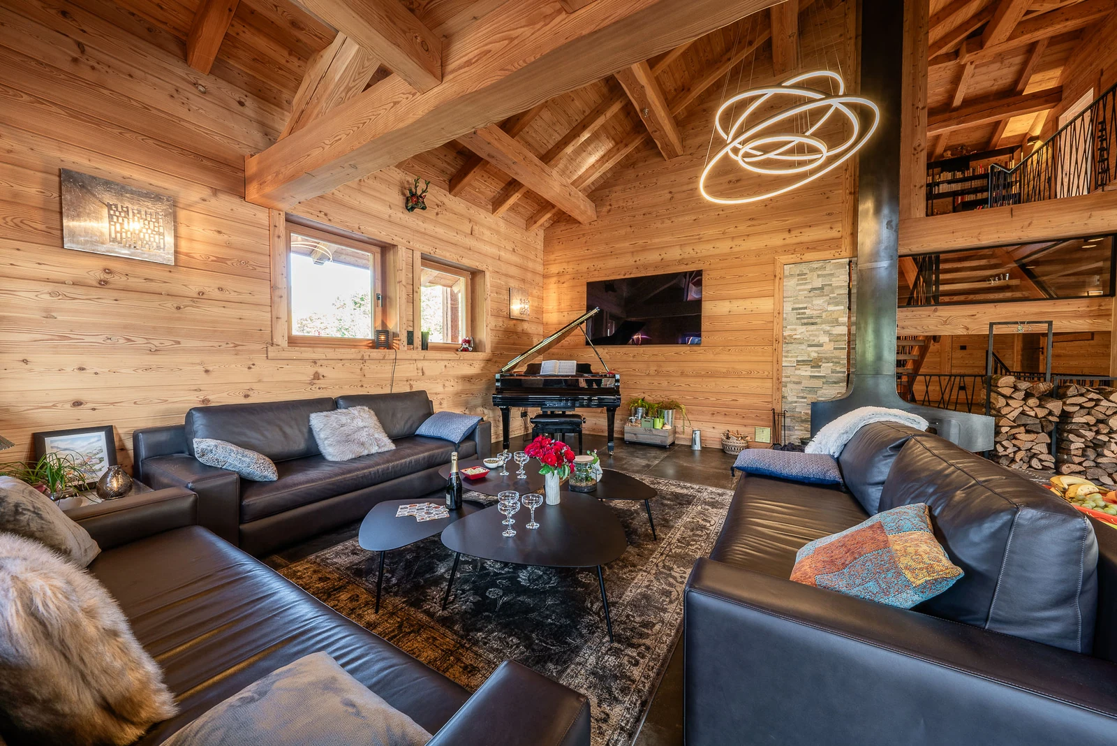 Chalet L'Étoile — salon avec piano et charpente apparente