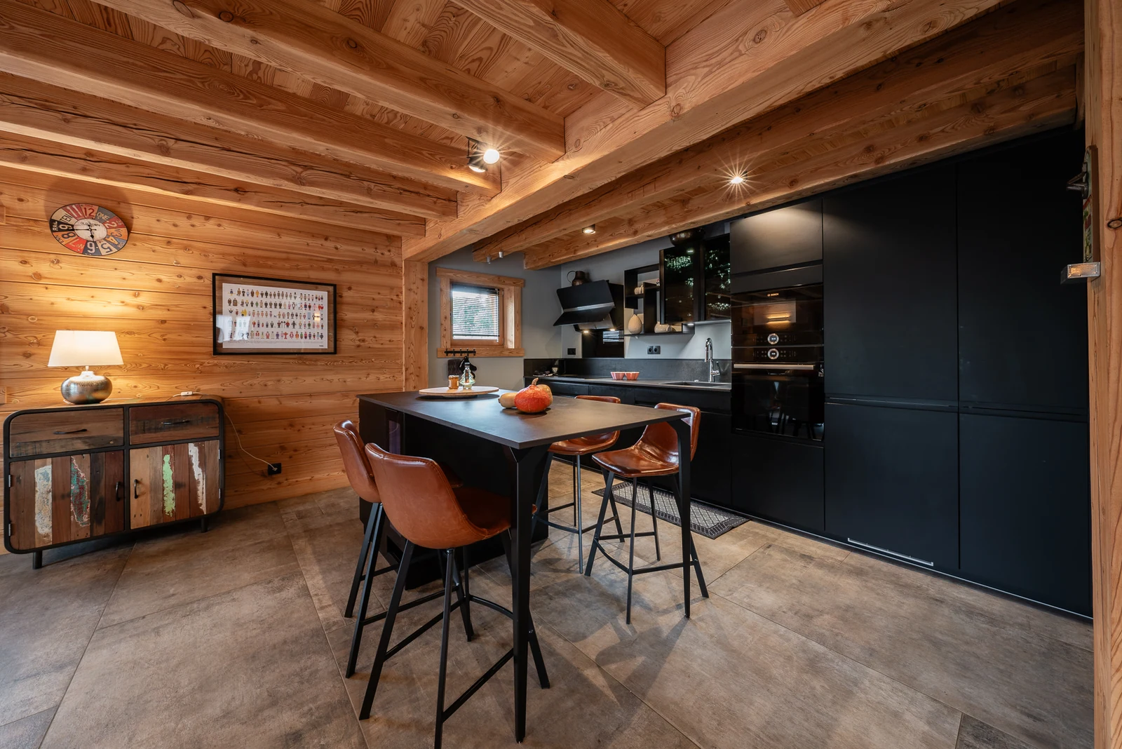 Chalet Le Mélézin — cuisine noire avec îlot et tabourets